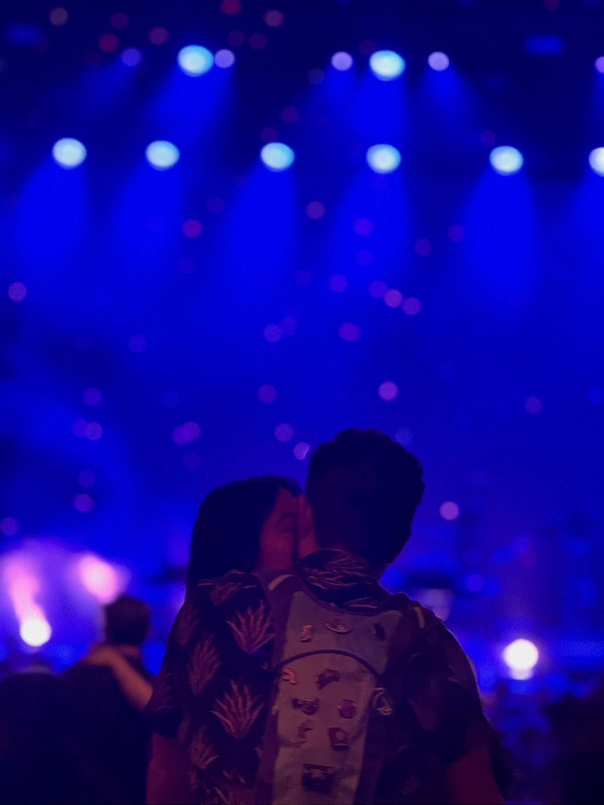 A kiss under blue concert lights
